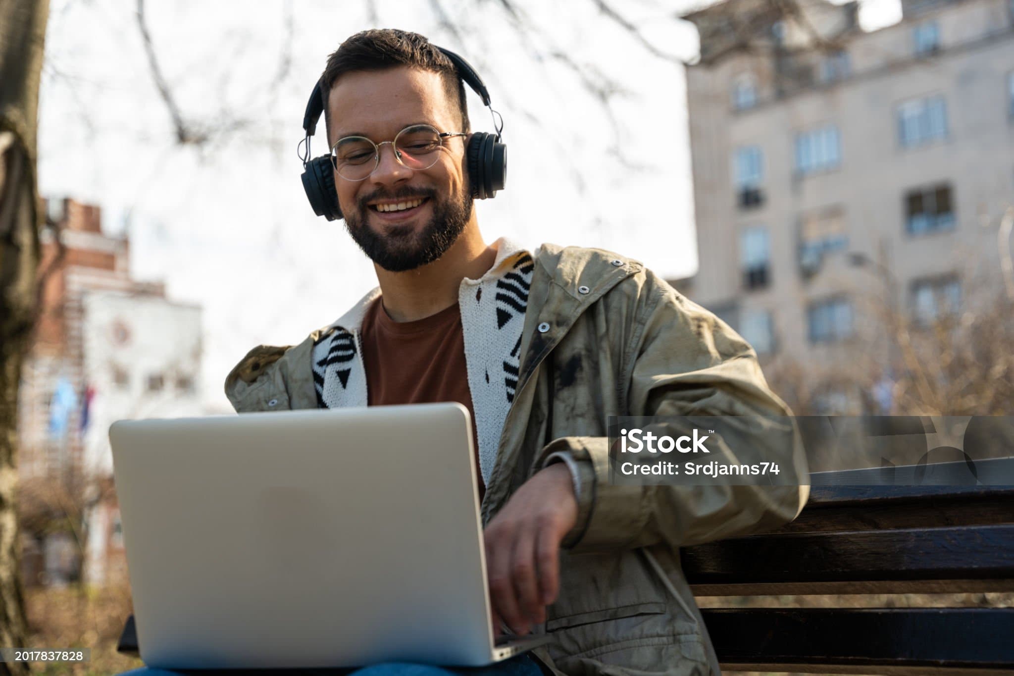 A musician working on a laptop with headphones on